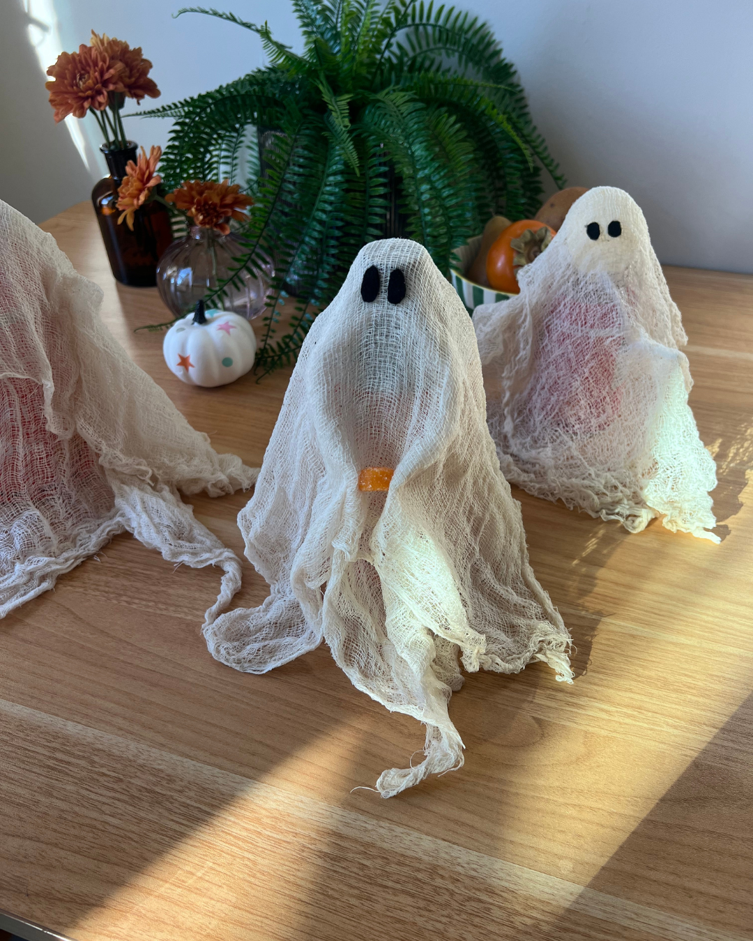 Cheesecloth ghost decor holding Qunol Turmeric 500mg gummy as a small pumpkin.